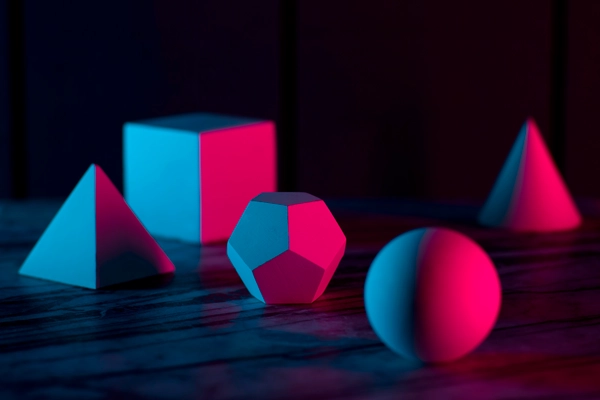 geometric shapes spread out on a table with dramatic lighting