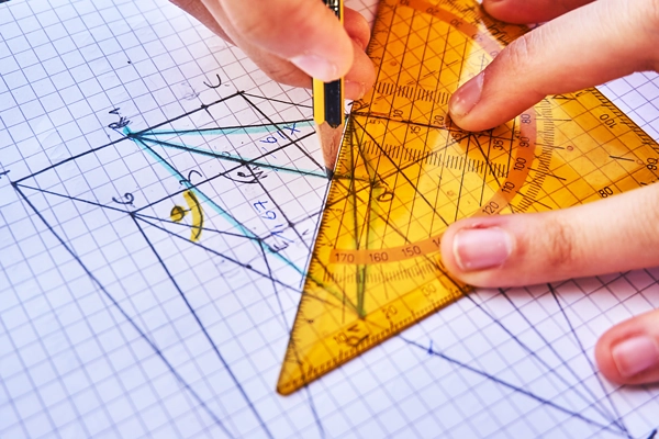 student using a triangle on graph paper