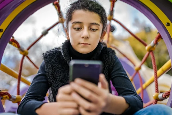 Little girl playing on mobile phone instead of enjoying the Park