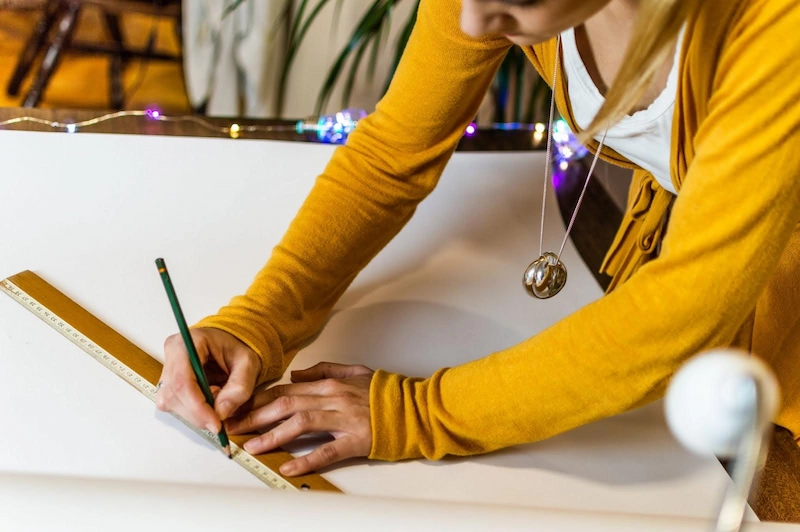 student using a ruler to graph out points on a chart